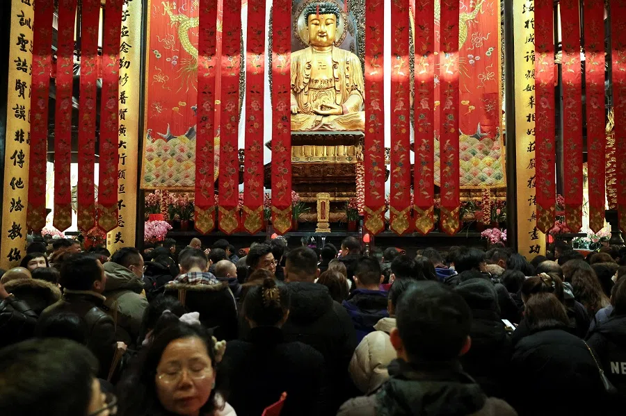 People gather in front of a Buddha statue to pray at Jade Buddha Temple in Shanghai, China, 28 January 2025. (Go Nakamura/Reuters)