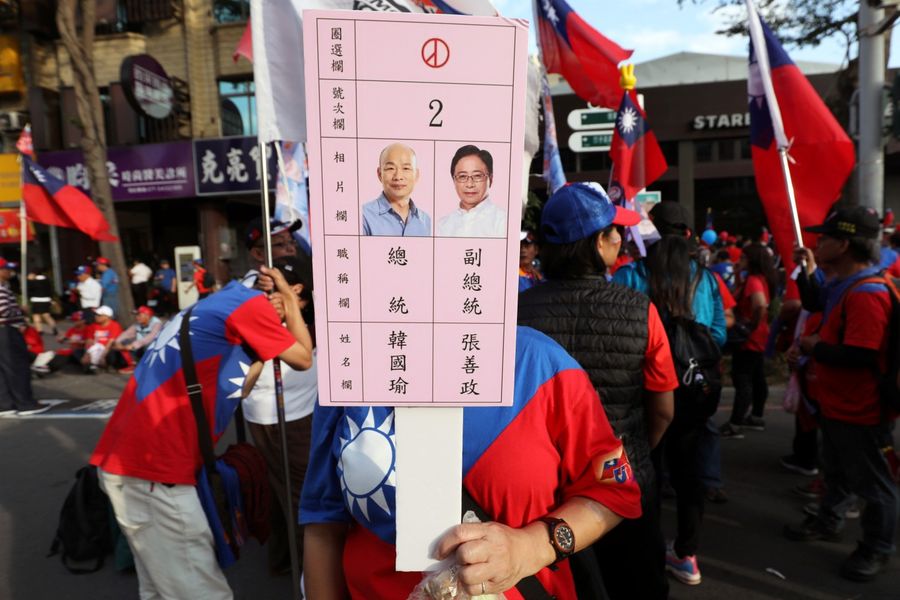 A supporter holds a placard depicting Taiwan's KMT party candidates Han Kuo-yu and Chang San-cheng during a campaign rally in Kaohsiung, Taiwan, on 21 December 2019. (Ann Wang/Reuters)