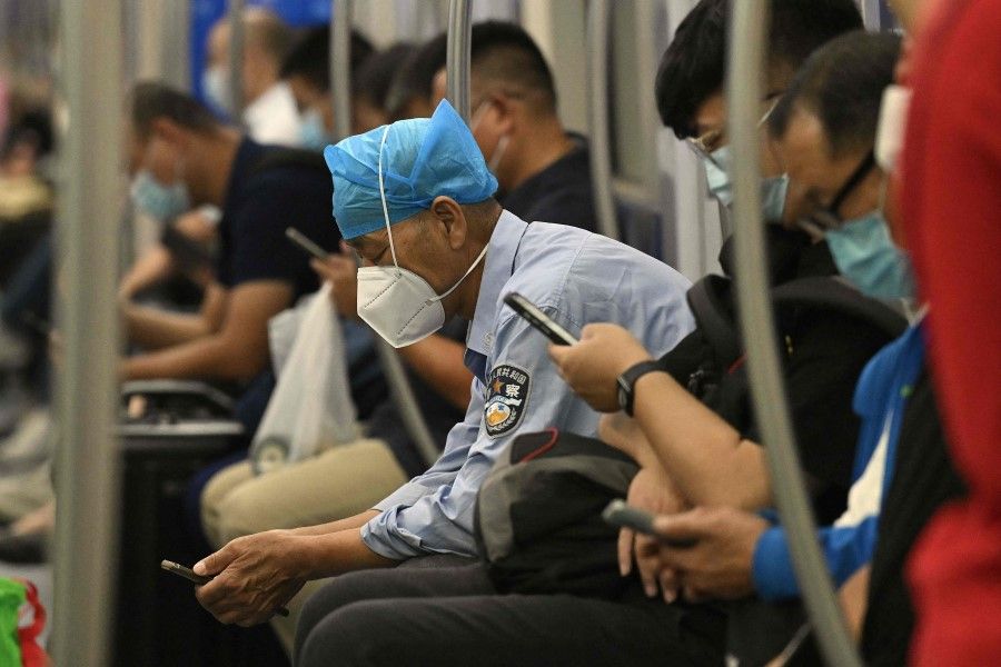 Passengers use their mobile phones on a subway train in Beijing on 28 September 2022. (Noel Celis/AFP)