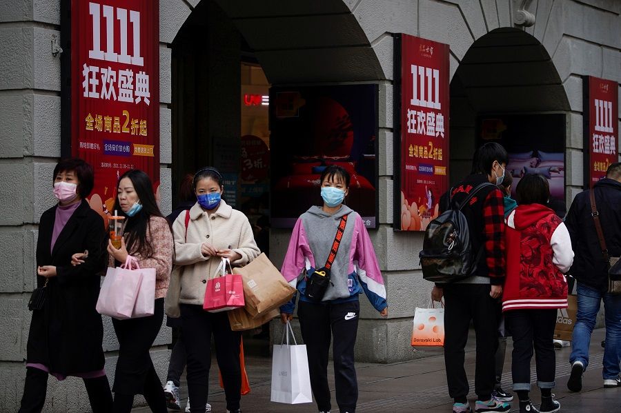 People walk along a main shopping area in Shanghai, China, 11 November 2021. (Aly Song/Reuters)
