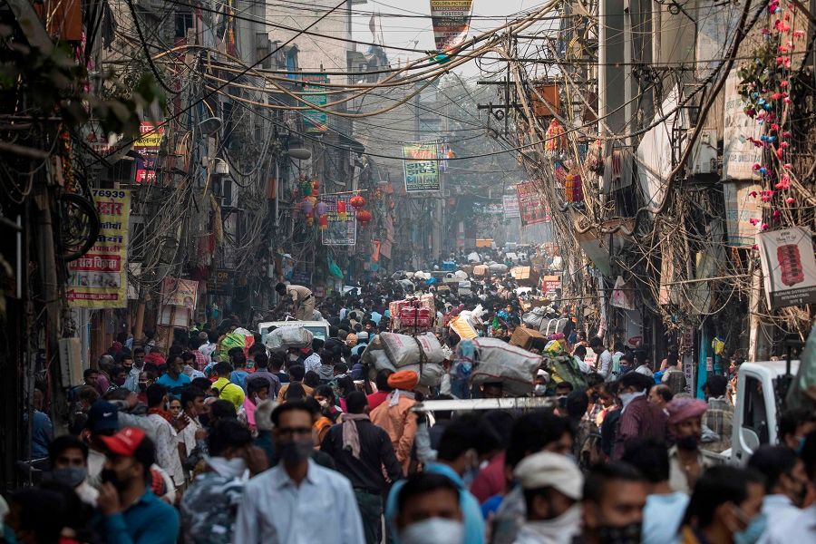People walk along a street of a market area amid the Covid-19 coronavirus pandemic in New Delhi on 7 November 2020. (Xavier Galiana/AFP)