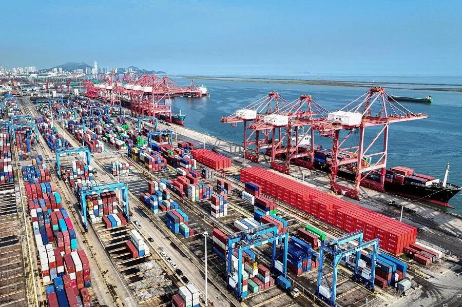 Shipping containers and gantry cranes are seen at a port in Lianyungang, in eastern China’s Jiangsu province on 7 August 2024. 