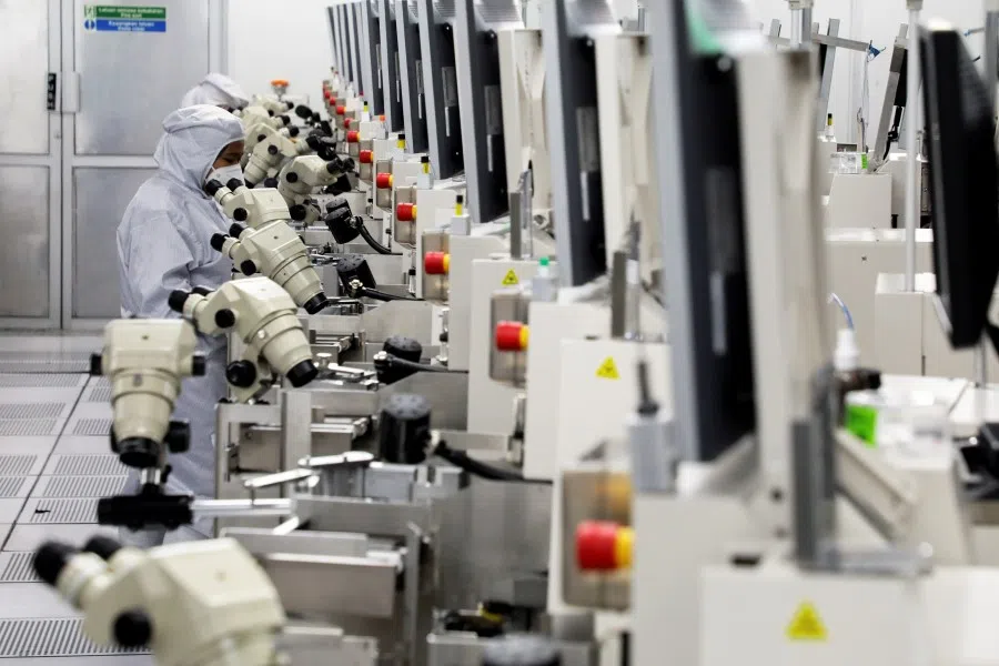 Workers monitor operations at the chip packaging firm Unisem (M) Berhad plant in Ipoh, Malaysia, 15 October 2021. (Lim Huey Teng/Reuters)