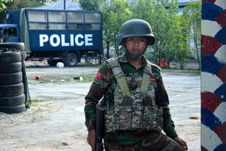 This photo taken on 9 November 2023 shows a fighter of the ethnic rebel group Ta'ang National Liberation Army (TNLA) standing guard in the town of Namhkam in northern Shan state. (Mai Nyi/AFP)