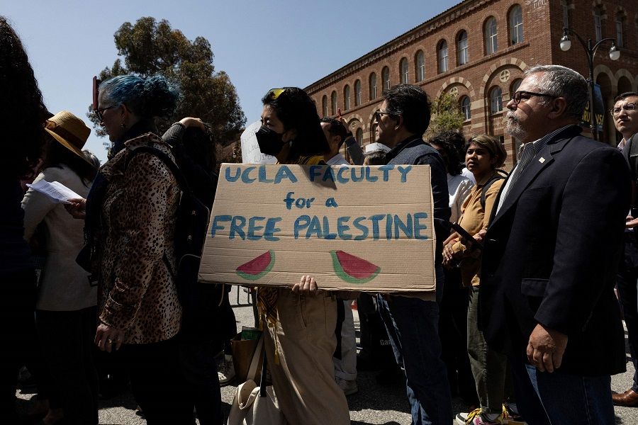 A demonstrator holds a poster reading “UCLA Faculty for a Free Palestine” as UCLA faculty and staff members demonstrate next to the pro-Palestinian encampment on the campus of the University of California, Los Angeles (UCLA) in Los Angeles, California, US, on 1 May 2024. (Etienne Laurent/AFP)