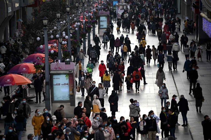 People walk along a shopping centre in Chengdu, the capital of southwest Sichuan province, on 28 November 2020. (Noel Celis/AFP)