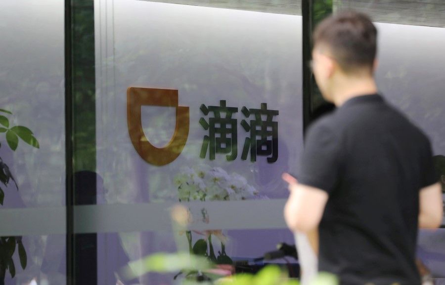 A man walks past the headquarters building of Chinese ride-hailing service Didi in Beijing, China, 5 July 2021. (Tingshu Wang/Reuters)