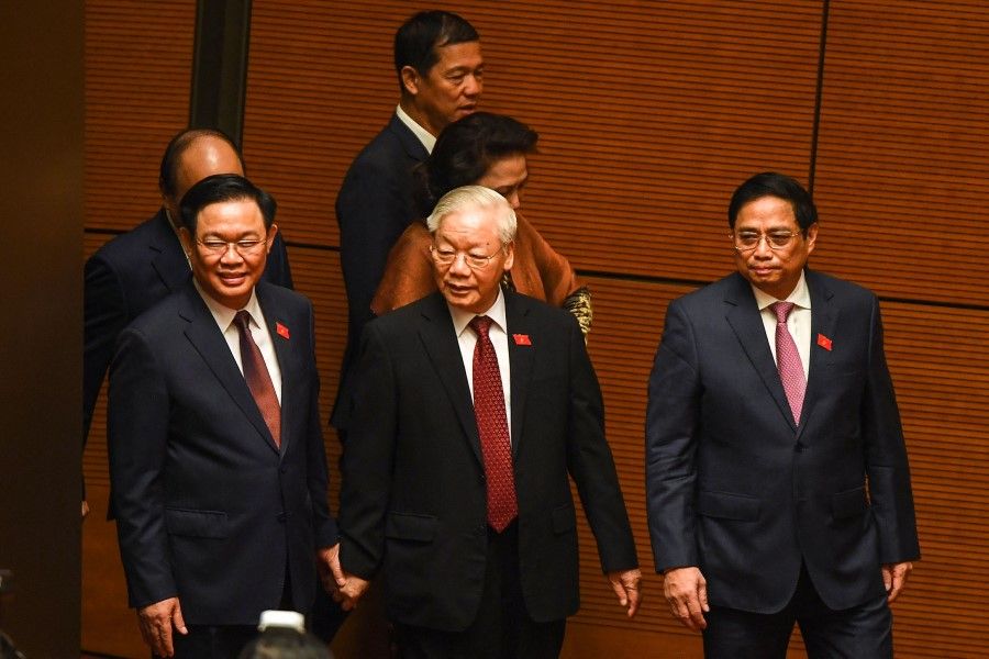 Vietnam's Communist Party General Secretary Nguyen Phu Trong (C) walks with Prime Minister Pham Minh Chinh (R) and National Assembly Chairman Vuong Dinh Hue (L) as they attend the opening of the National Assembly's autumn session in Hanoi on 20 October 2022. (Nhac Nguyen/AFP)