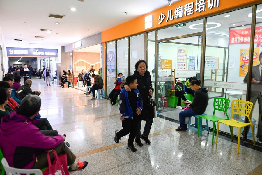 This picture taken on 8 November 2019 shows parents and guardians waiting outside a children's computer coding training centre in Beijing. (Wang Zhao/AFP)