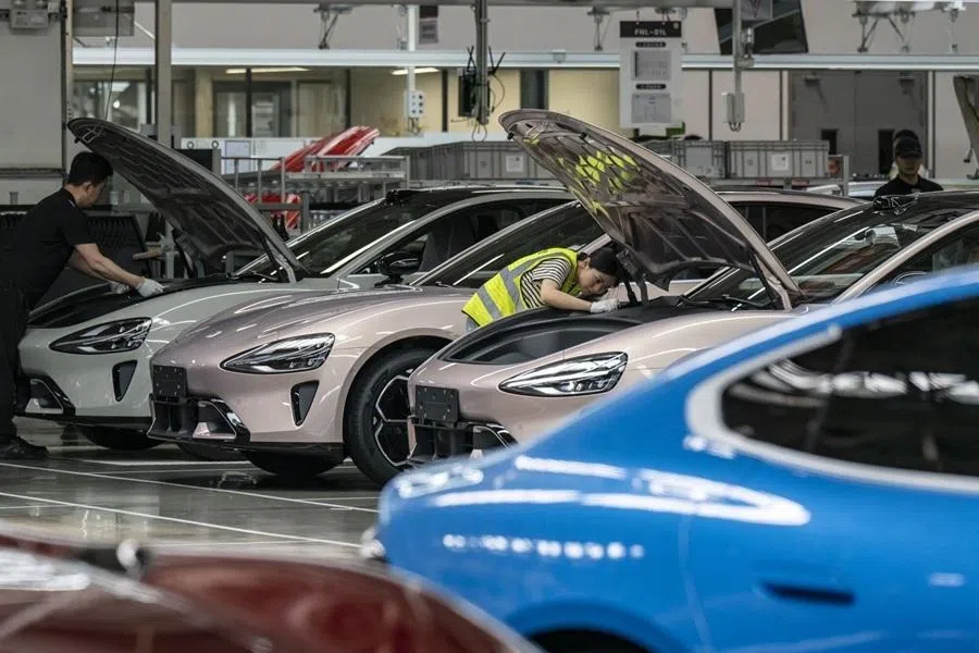 Workers inspect Xiaomi Corp. SU7 electric vehicles after rolling off the assembly line at the company's production facility in Beijing, China, on 29 May 2026.