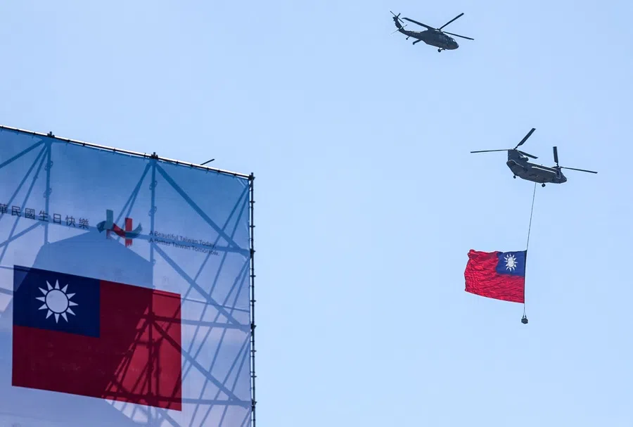 A CH-47SD carrying a Taiwan flag and a UH-60M helicopter fly past during Double Ten Day celebrations at the Presidential Palace in Taipei on 10 October 2025.