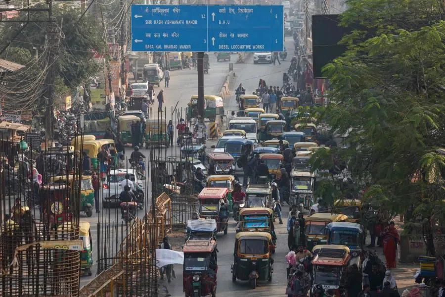 Electric and auto rickshaws commute through traffic along a street in Varanasi on 10 December 2025. (Niharika Kulkarni/AFP)
