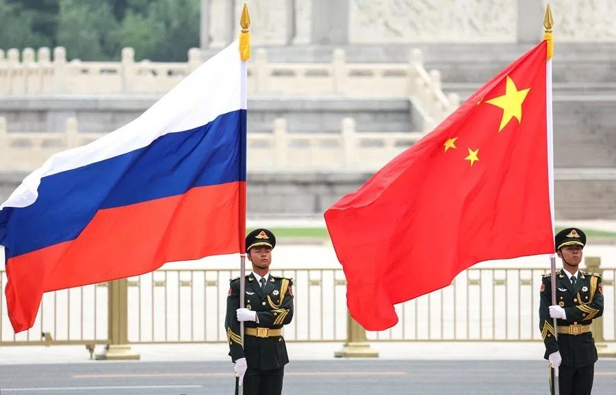 Chinese guards hold Russian and Chinese flags during a welcoming ceremony for Russian President Vladimir Putin at the Great Hall of the People in Beijing, China, on 20 May 2026.