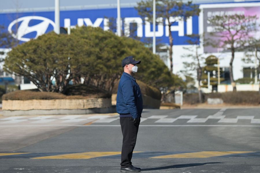 In a photo taken on 10 February 2020, a security guard stands at the entrance to the Hyundai Motor Asan Factory in Asan, south of Seoul. Hyundai has had to suspend production at its factories across South Korea, putting 25,000 workers on forced leave and partial wages, hamstrung by a lack of parts with the coronavirus outbreak crippling China's industrial output. (Yelim Lee/AFP)