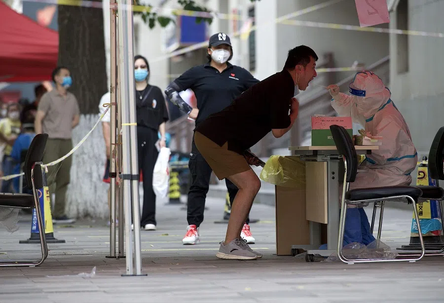 A health worker gets a swab sample from a man to be tested for Covid-19 at a swab collection site in Beijing, China, on 22 May 2022. (Noel Celis/AFP)