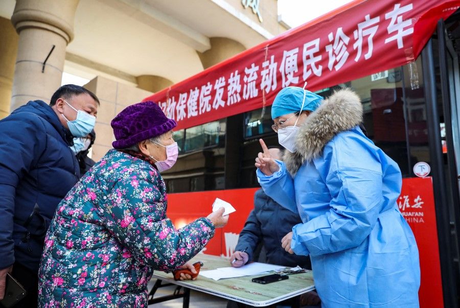 A medical worker provides instructions to a resident at a mobile fever clinic converted from a bus amid the Covid-19 outbreak, in Huaian, Jiangsu province, China, 25 December 2022. (CNS photo via Reuters)
