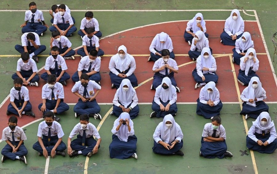 Students gather as schools transition to in-classroom teaching amid the Covid-19 coronavirus pandemic in Jakarta on 3 January 2022. (Adek Berry/AFP)