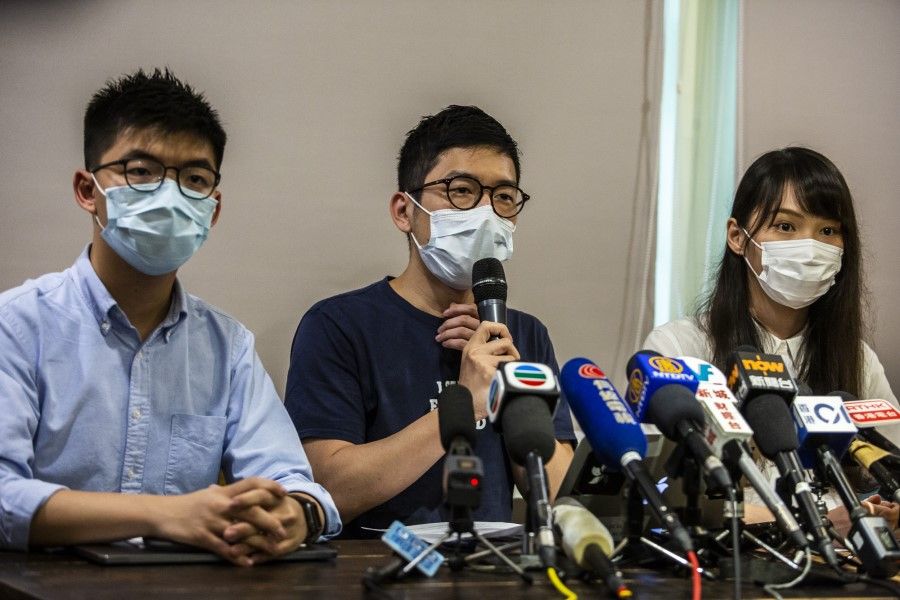 Joshua Wong (L), Nathan Law (C) and Agnes Chow (R) of pro-democracy political group Demosisto hold a press conference in Hong Kong on 30 May 2020. On 30 June, the three announced they were stepping down. (Isaac Lawrence/AFP)