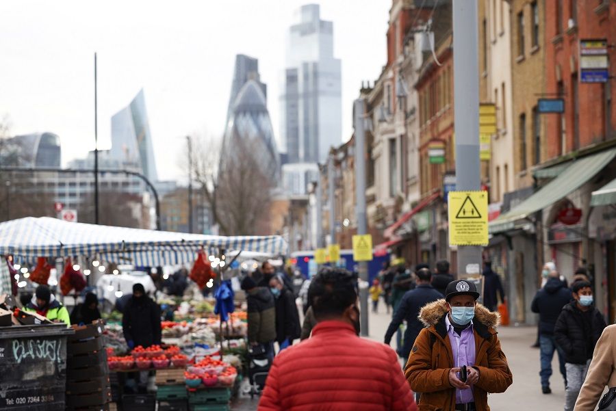 People walk past shops and market stalls, amid the Covid-19 outbreak in London, Britain, 15 February 2021. (Henry Nicholls/Reuters)