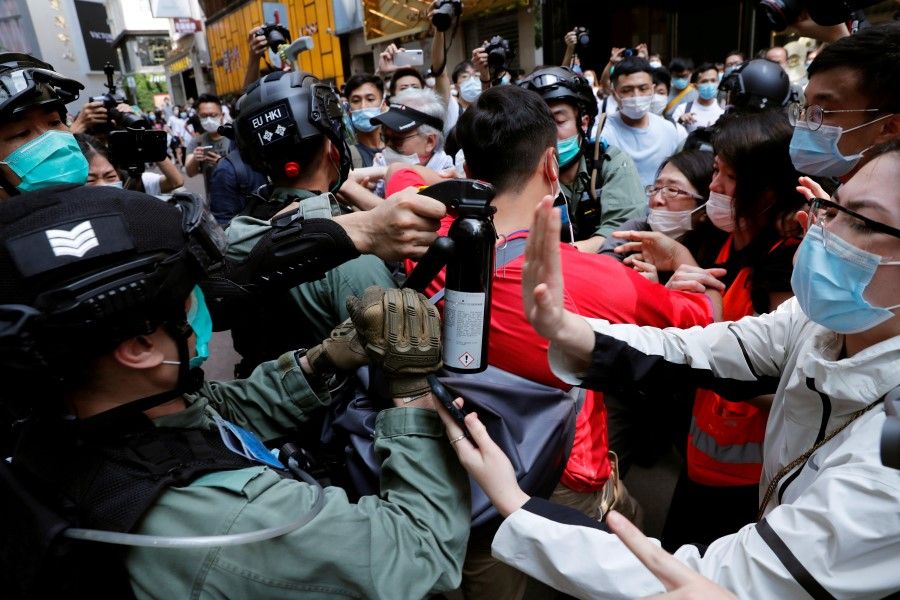 Anti-government demonstrators scuffle with riot police during a lunch time protest as a second reading of a controversial national anthem law takes place in Hong Kong, 27 May 2020. (Tyrone Siu/REUTERS)