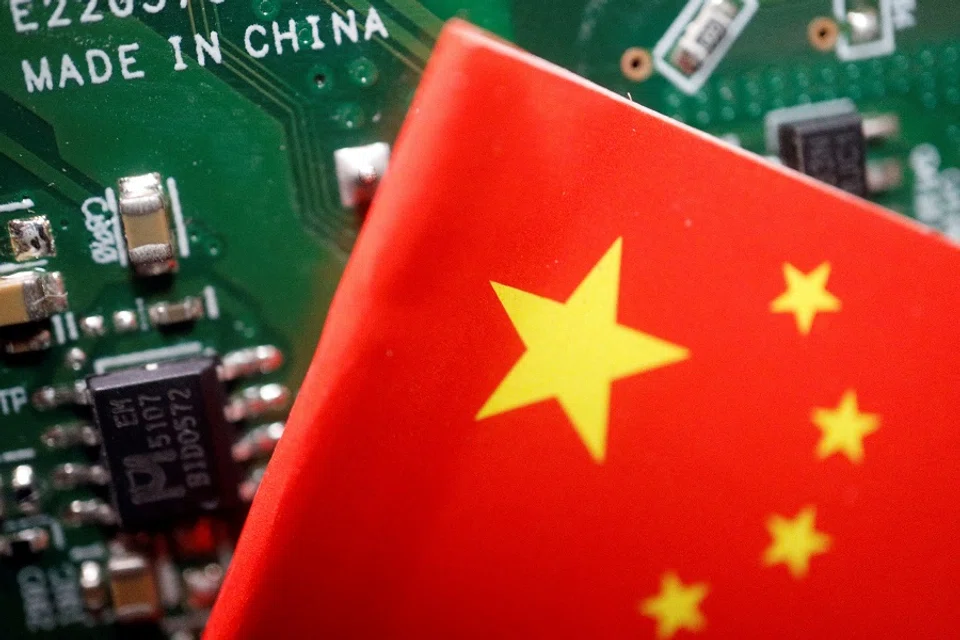A Chinese flag is displayed next to a “Made in China” sign seen on a printed circuit board with semiconductor chips, in this illustration picture taken on 17 February 2023. (Florence Lo/Reuters)