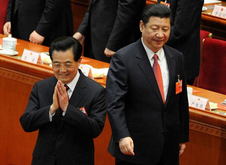 In this file photo taken on 14 March 2013, China's former president Hu Jintao (left) gestures as newly elected President Xi Jinping (centre, right) walks past during the election of the new president of China at the 12th National People's Congress in the Great Hall of the People in Beijing. (Mark Ralston/AFP)