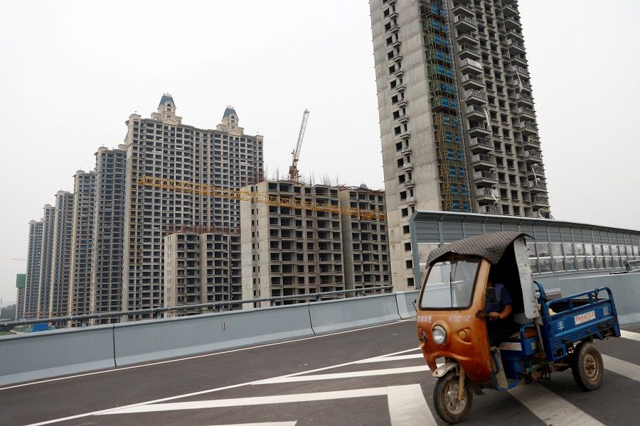 A vehicle drives past unfinished residential buildings at Evergrande Oasis, a housing complex developed by Evergrande Group, in Luoyang, China, 16 September 2021. (Carlos Garcia Rawlins/File Photo/Reuters)