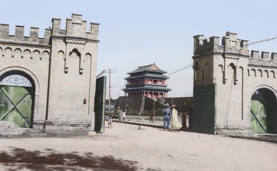 After the Boxer Rebellion ended in 1915, according to the Boxer Protocol, the Beijing Legation Quarter was planned by a public agency in charge of managing embassies. Besides the city wall and moat to the south, brick walls over ten Chinese feet (3.3 metres) high were built to the east, north and west. Ditches were dug outside the walls, with "eight towers all around, each with metal gates". This photo is a view of Chongwen Gate Tower as seen from within the east gate of East Jiaomin Lane (東交民巷), showing the Beijing Legation Quarter as a fortified area with the armies of various countries stationed there.
