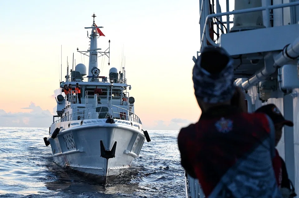 A Philippines coast guard personnel looks at the Chinese Coast Guard vessel as they come close during a mission to deliver provisions at Second Thomas Shoal in the South China Sea on 10 November 2023. (Jam Sta Rosa/AFP)