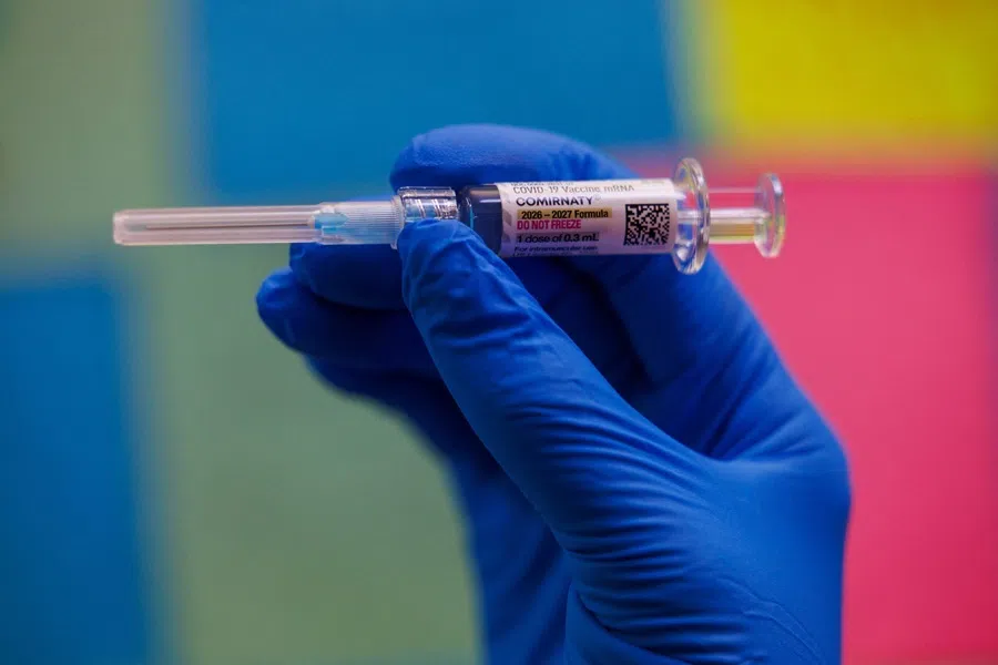 A person poses with a dose of Pfizer’s Covid-19 vaccine in this illustration picture taken in Schwenksville, Pennsylvania, US, 18 September 2026.