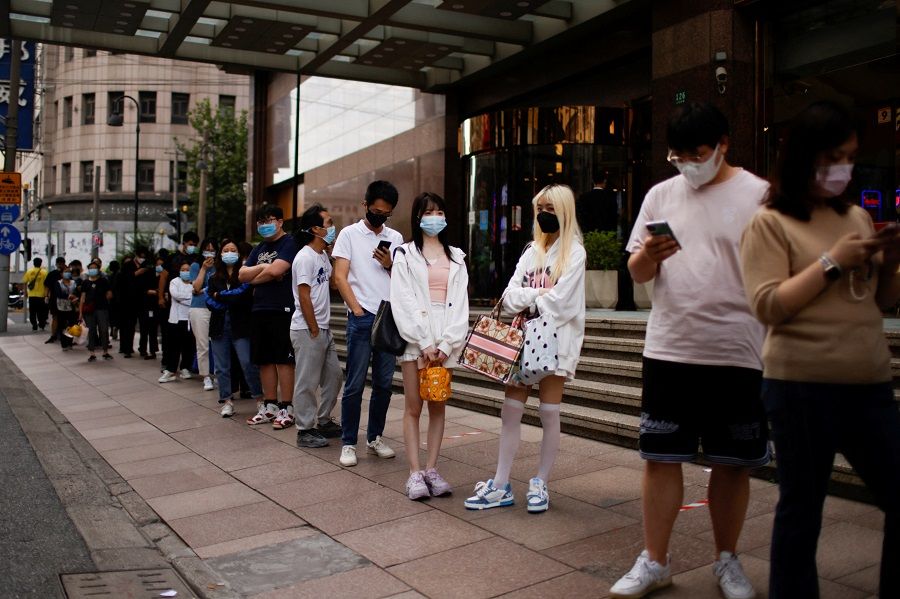 People line up to get tested for Covid-19 at a nucleic acid testing site on a street in Shanghai, China, 21 September 2022. (Aly Song/Reuters)