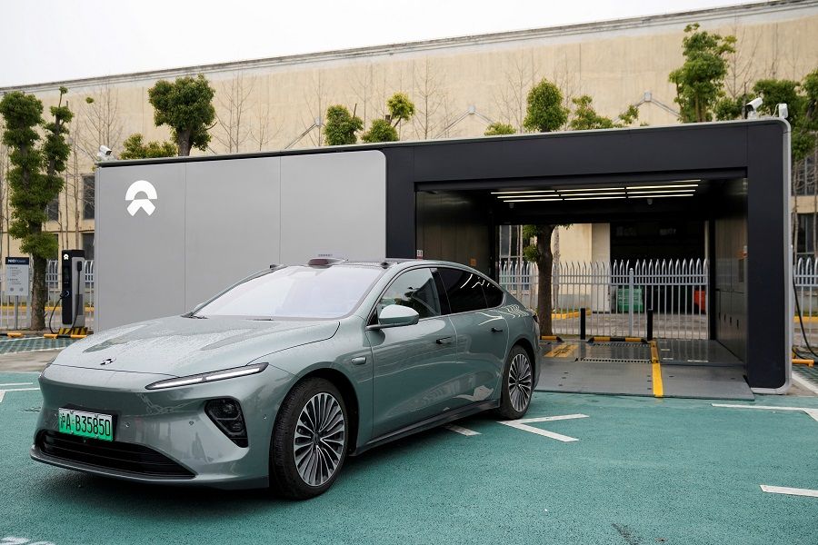 A staff member of Chinese electric vehicle (EV) maker Nio drives a Nio car as he demonstrates to the media about the operation of the new battery swapping station, at a delivery centre of the company, in Nanxiang, Shanghai, China, 23 March 2023. (Aly Song/Reuters)