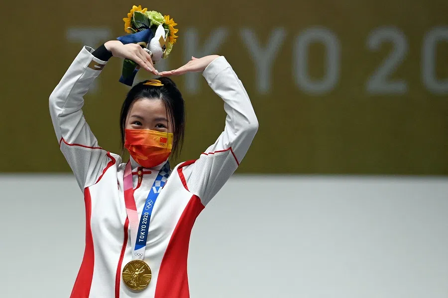 China's Yang Qian celebrates on the podium after winning the women's 10m air rifle final during the Tokyo 2020 Olympic Games at the Asaka Shooting Range in the Nerima district of Tokyo, Japan, on 24 July 2021. (Tauseef Mustafa/AFP)
