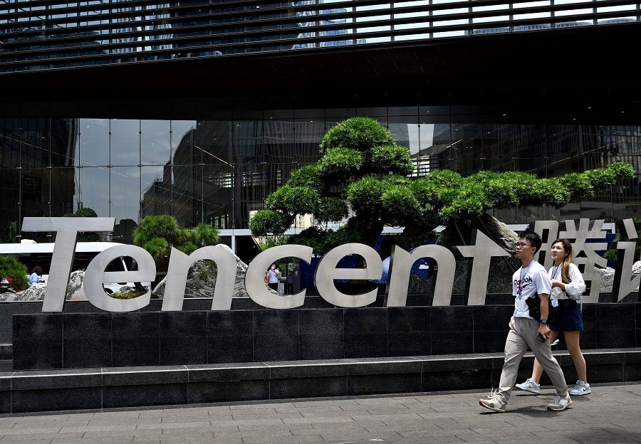This photo taken on 26 May 2021 shows people walking past the Tencent headquarters in Shenzhen, Guangdong province, China. (Noel Celis/AFP)