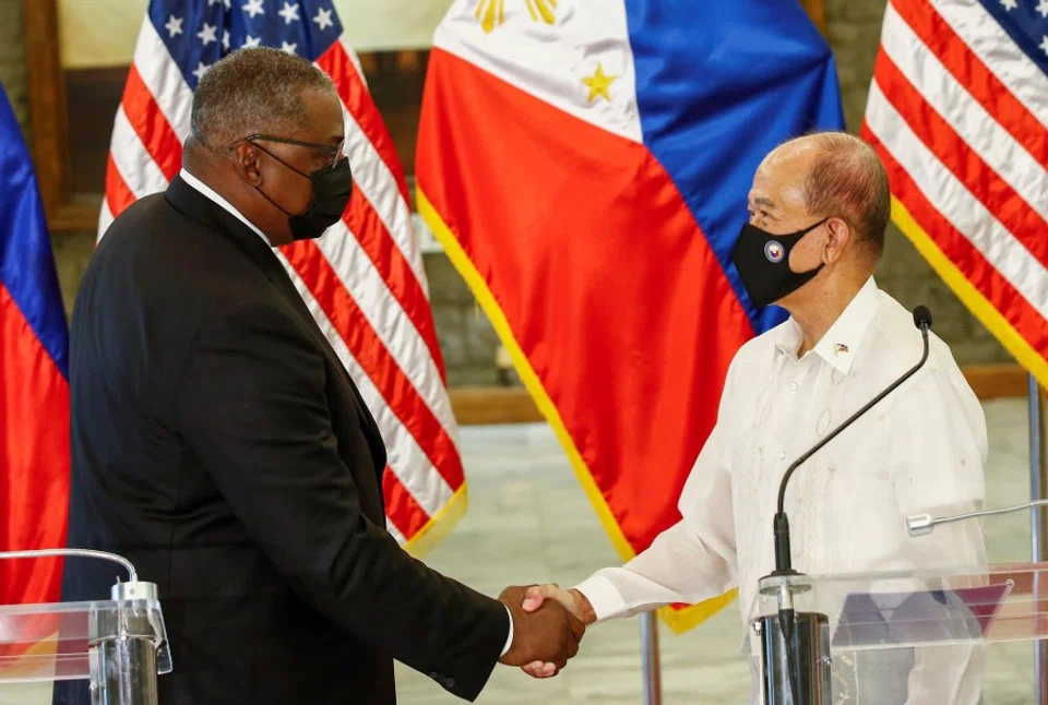 US Defence Secretary Lloyd Austin (left) and Philippine Defence Secretary Delfin Lorenzana (right) shake hands after a bilateral meeting at Camp Aguinaldo military camp in Quezon City, Metro Manila, Philippines, 30 July 2021. (Rolex Dela Pena/Pool via Reuters)