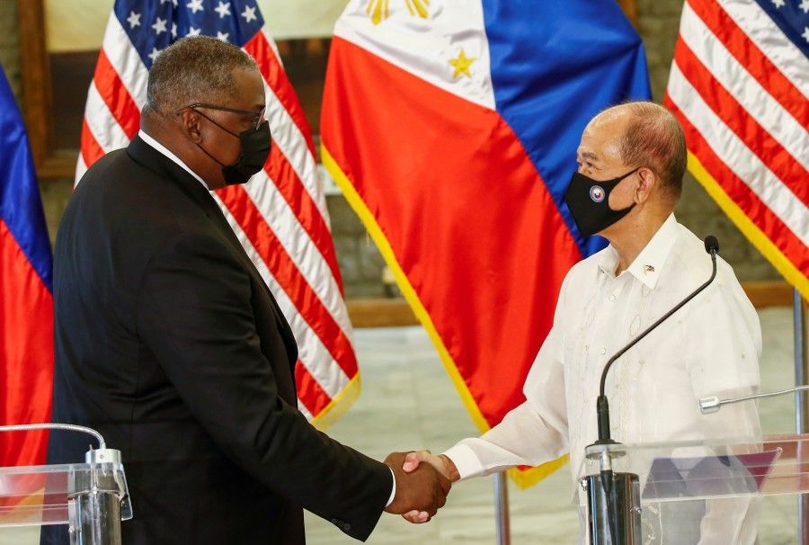 US Defence Secretary Lloyd Austin (left) and Philippine Defence Secretary Delfin Lorenzana (right) shake hands after a bilateral meeting at Camp Aguinaldo military camp in Quezon City, Metro Manila, Philippines, 30 July 2021. (Rolex Dela Pena/Pool via Reuters)