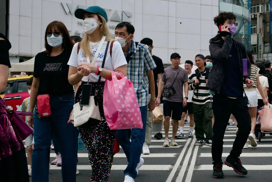 This picture taken on 14 April 2023 shows people walking down a street in the Ximen district in Taipei. (Sam Yeh/AFP)
