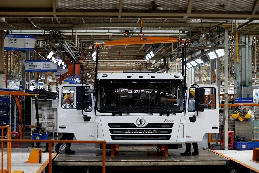 Employees work on the trucks production line during an organised media tour to the Shaanxi Automobile Group factory in Xian, Shaanxi province, China, on 17 May 2023. (Florence Lo/Reuters)