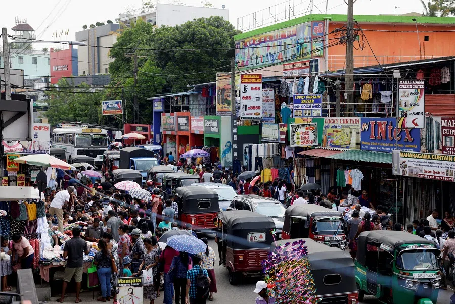 People gather around clothing stalls to buy clothes ahead of the Sinhala and Tamil New Year festival, in Colombo, Sri Lanka, 11 April 2023. (Dinuka Liyanawatte/Reuters)