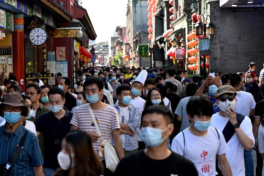 People walk in Qianmen street in Beijing on 21 September 2021. (Noel Celis/AFP)