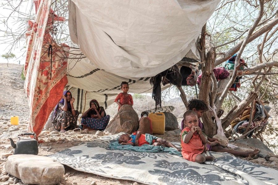 Internally displaced people seat in a tent in the makeshift camp where they are sheltered in the village of Erebti, Ethiopia, on 9 June 2022. (Eduardo Soteras/AFP)