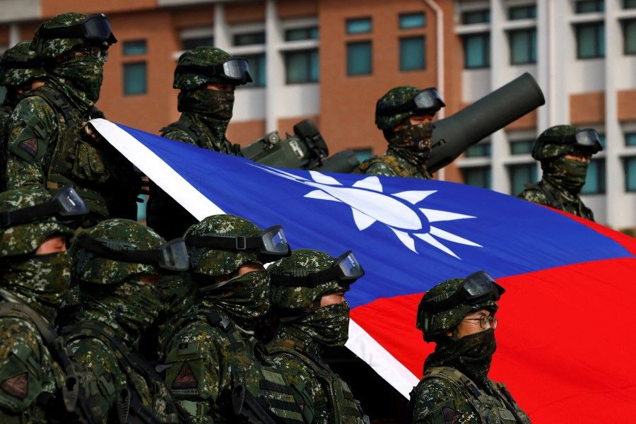 Taiwan's armed forces pose for a photo with a Taiwan flag during a routine drills to show combat readiness ahead of Lunar New Year holidays at a military base in Kaohsiung, Taiwan, 11 January 2023. (Ann Wang/Reuters)