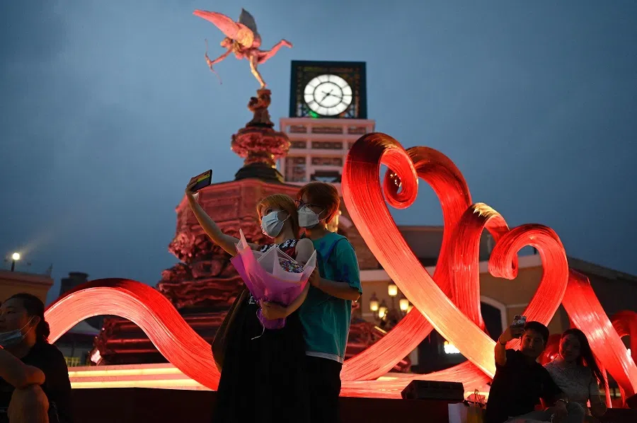 A couple poses for photographs at a shopping mall during the Qixi Festival, also known as Chinese Valentine's Day, in Beijing, China, on 14 August 2021. (Jade Gao/AFP)