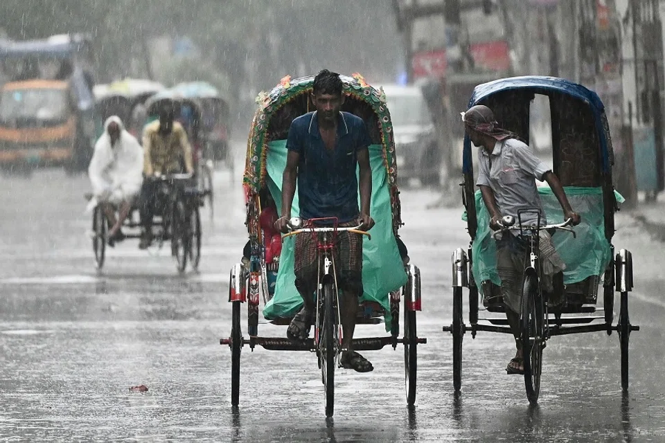 Rickshaw pullers make their way along a street during a rainfall in Dhaka, Bangladesh, on 9 June 2023. (Munir Uz Zaman/AFP)