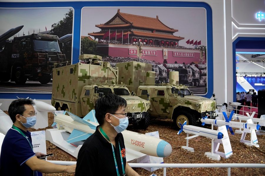 People walk past models of missiles and military vehicles displayed at the China International Aviation and Aerospace Exhibition, or Airshow China, in Zhuhai, Guangdong province, China, 28 September 2021. (Aly Song/Reuters)