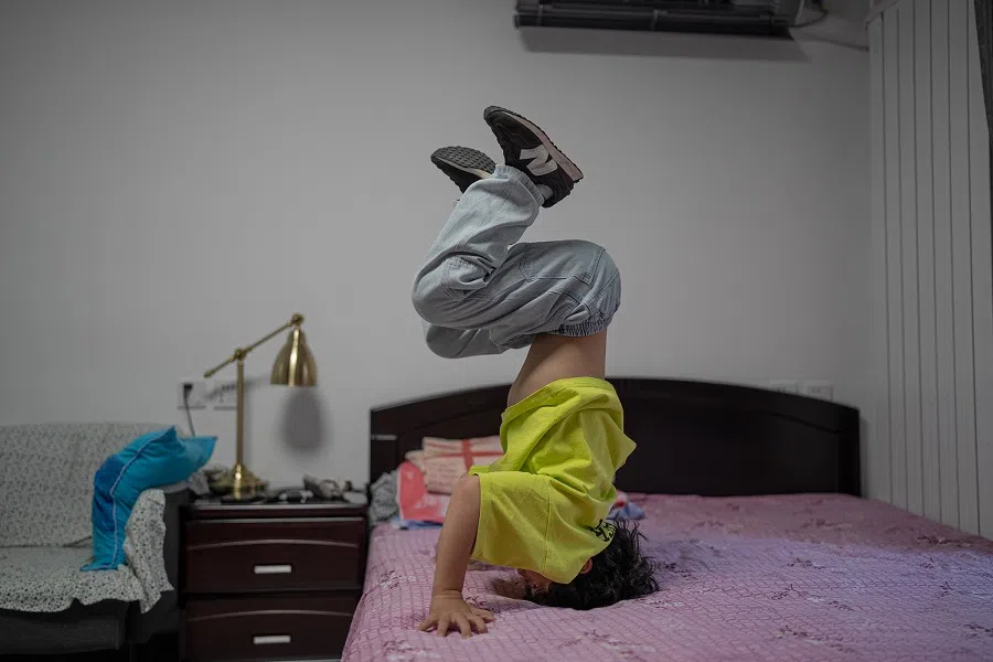 Zhuangzhuang practising handstands on the bed.