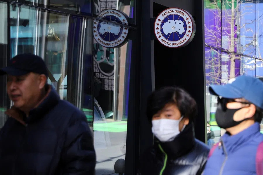 People walk past a Canada Goose store in Beijing, China, 2 December 2021. (Tingshu Wang/Reuters)