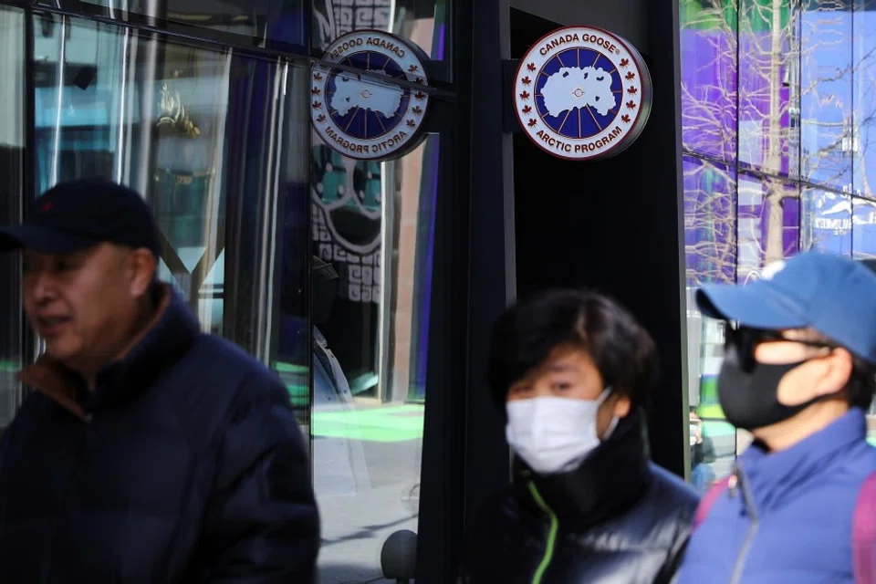 People walk past a Canada Goose store in Beijing, China, 2 December 2021. (Tingshu Wang/Reuters)