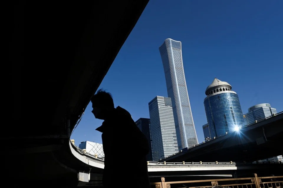 A pedestrian walks at Central Business District (CBD) in Beijing on 16 January 2023. (Wang Zhao/AFP)