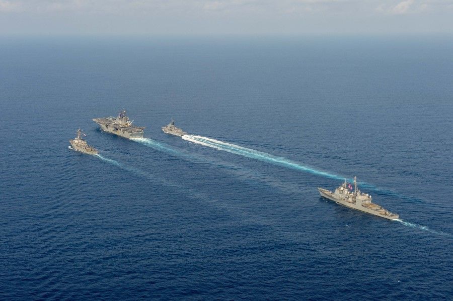 (L-R) Royal Australian Navy helicopter frigate HMAS Parramatta (top right) conducts officer of the watch manoeuvres with amphibious assault ship USS America (top middle), guided-missile destroyer USS Barry (top left) and guided-missile cruiser USS Bunker Hill (right) in the South China Sea, in this 18 April 2020 handout photo. (Australia Department Of Defence/Handout via REUTERS)
